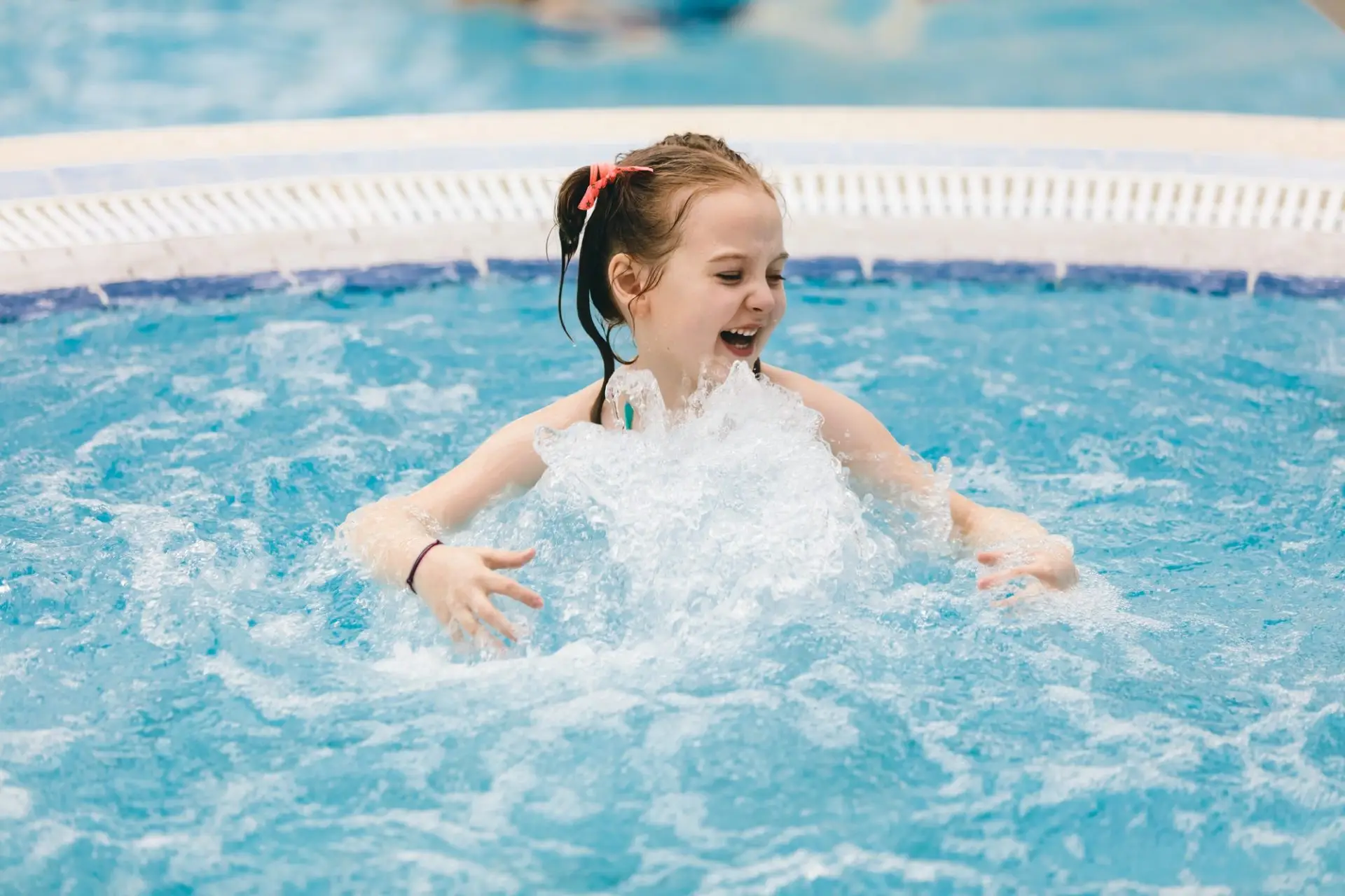 little child enjoying her time in a hot tub e1628825976979